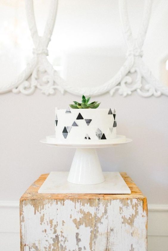 a simple modern cake with grey geo decor and a succulent