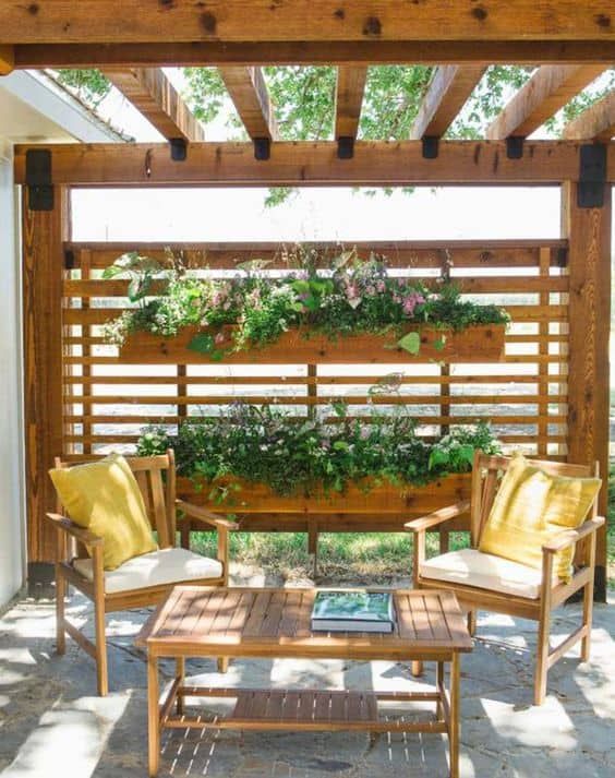 a pergola with privacy screens and vertical planters, stained furniture and a coffee table is welcoming