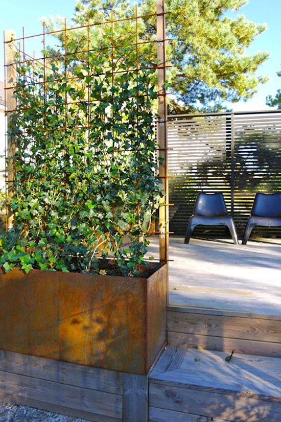 a privacy screen and a trellis with a metal planter and greenery are cool for making your space private