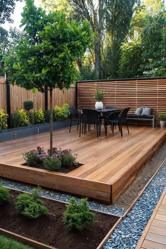 a stylish modern terrace with stained screens, raised garden beds with greenery and blooms, a tree and black outdoor furniture