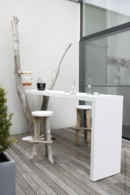 a white built-in tabletop and wood and plastic stools for a small dining space
