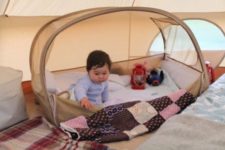 06 a small outdoor baby tent in beige placed inside an adult’s tent