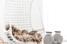 07 a white wicker hanging chair with faux fur for a Scandinavian interior