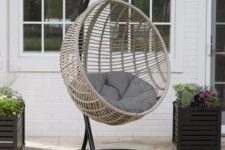 14 a hanging egg chair with a cushion and a metal stand will make your outdoor space modern