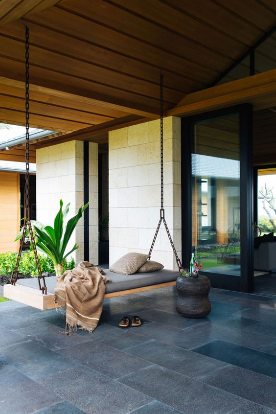 a modern chain hanging bed on the porch for a fast nap
