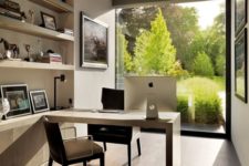 14 a modern rather small home office with a glass wall coming to an English garden