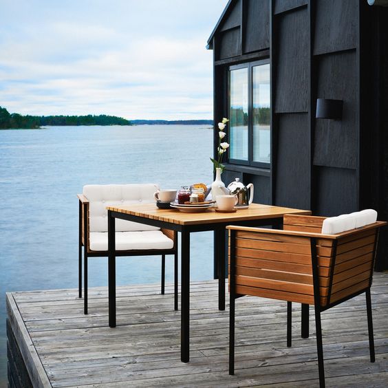 simple wooden upholstered chairs and a small table on a deck to take them inside easily