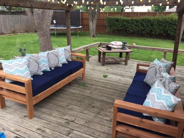 stained wood sofas with navy cushions and patterned pillows