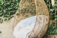 21 wicker egg-shaped chair suspended in an outdoor space for relaxation
