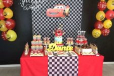 02 a Cars-themed dessert table with a checked fabric backdrop, black, red and yellow decor