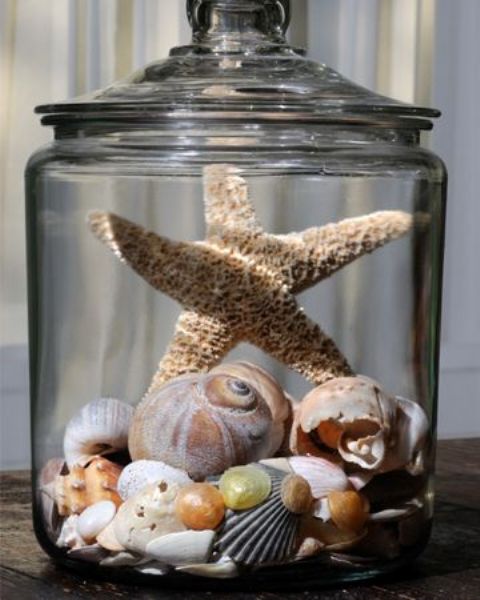 a jar with shells, beads and a star fish for a natural beach look