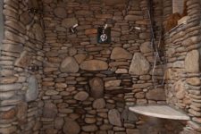 04 a stone clad shower with a pebble tile floor looks rustic and cool