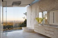 04 open bathroom concept with a glass wall that overlooks the woodland and the city on the distance
