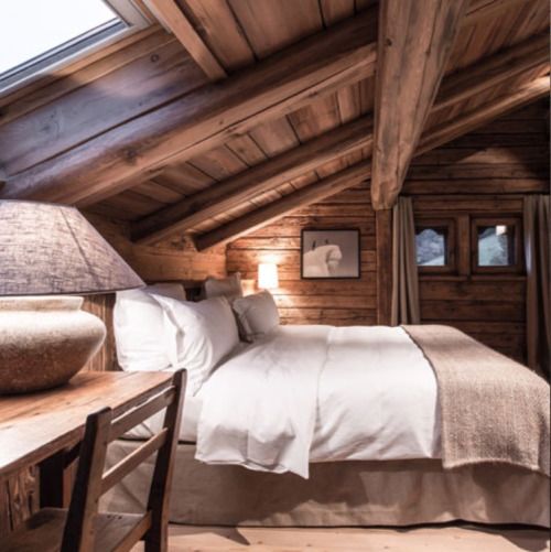 a chalet bedroom with a skylight for some natural light looks very cozy