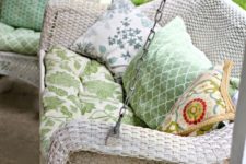 05 a whitewashed wicker swing with green upholstery for relaxing on your porch after a long day