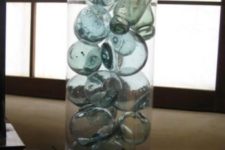 07 small fishing floats look gorgeous as a group in a tall vase placed on a window sill with the light shining through