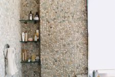 07 the bathroom completely covered with pebble tiles looks unusual and creative