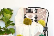 10 a white crochet blanket with large bold green pompoms if the night is cold