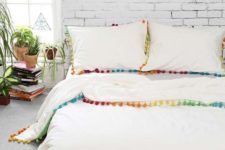 11 colorful pompoms lining the bedding automatically makes it summery
