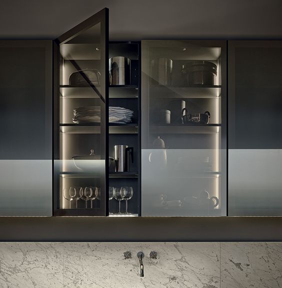 a kitchen cabinet with smoke glass doors shows off the glasses and dishes but gently