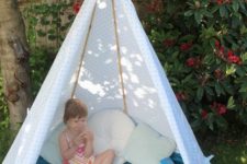 13 a small kids’ teepee with a blue blanket and a polka dot cover, some soft pillows