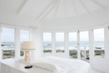 14 a white bedroom with lots of windows and skylights that offer coastal views