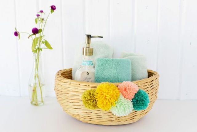 decorate your bathroom basket with colorful pompoms for summer