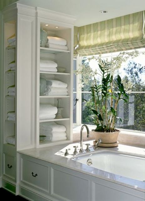 built in open shelves next ot the bathtub are a very comfy idea