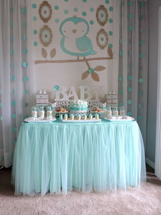 a dessert table with an owl backdrop in aqua color