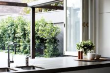 07 a folding window opens the kitchen to outdoors, and turns it into an outdoor-indoor space