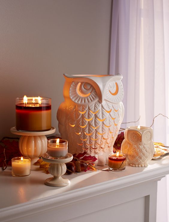 a large owl candle holder with candles, acorns and fall leaves for a fall display