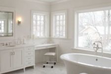 09 an all-white bathroom with marble, a free-standing bathtub and a glam chandelier