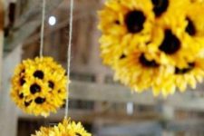 10 faux sunflower balls hanging over the window for a bright feel