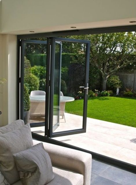 a black framed folding door helps to open the space to the backyard