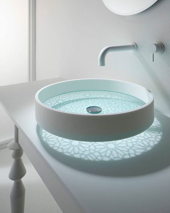 a round glass sink with frosted patterns and a white side