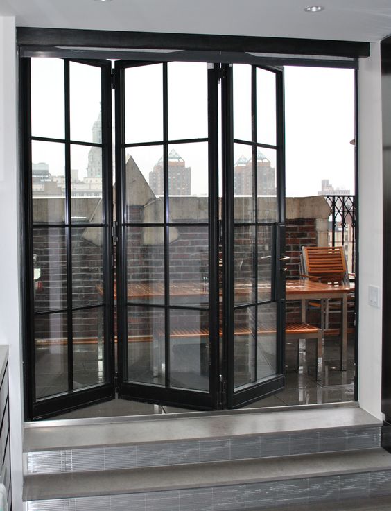 a large black framed folding door is an entrance to the balcony
