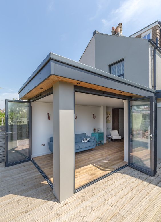 a living room corner completely opened to outdoors with two folding doors