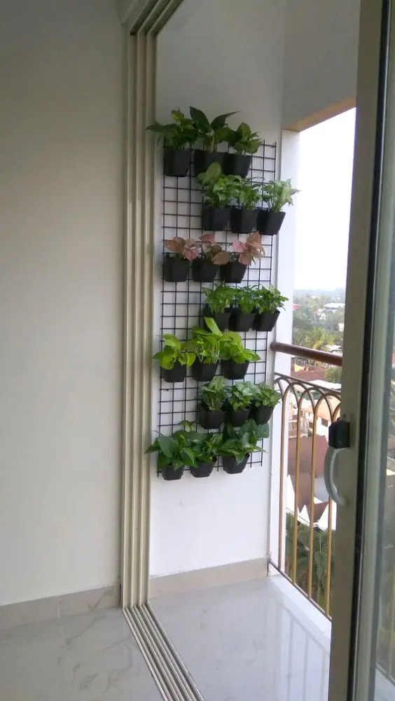 a grid with matching black planters with greenery is a cool and easy way to refresh your balcony without wasting floor space