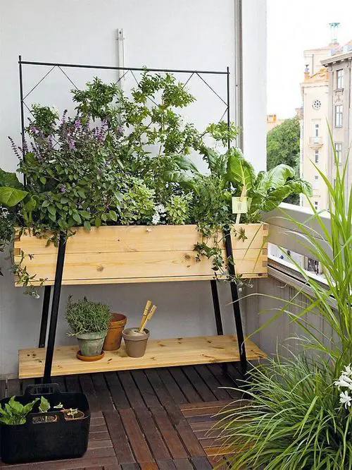 a tiered unit with a shelf and a planter is a cool option of a small balcony garden, you may grow veggies and herbs