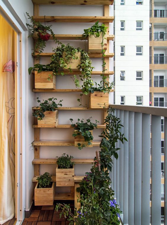 a wooden shelf with built-in planters and greenery is a super cool idea for a modern and cozy balcony