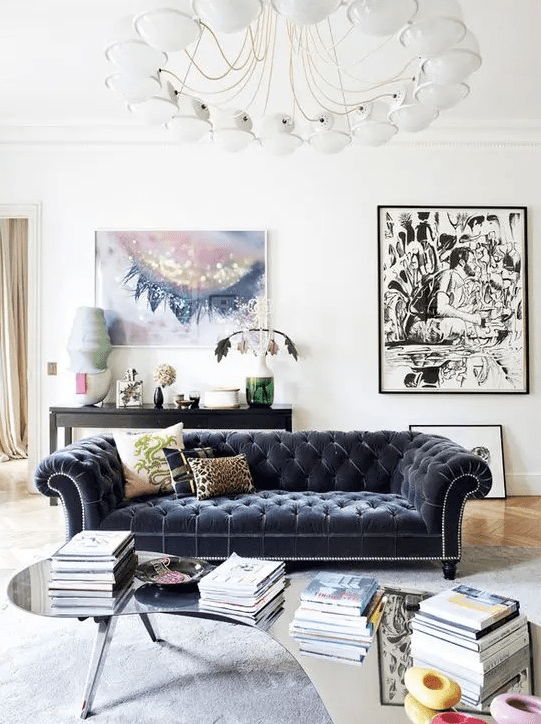 an airy living room in neutral shades with a graphite grey velvet Chesterfield and artworks