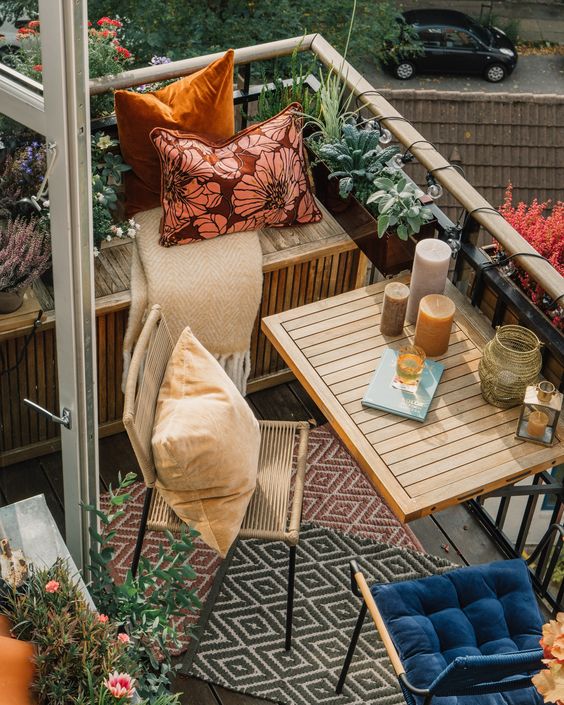 small hanging planters with herbs, crate furniture and rattan chairs are a cool combo for a lovely small balcony
