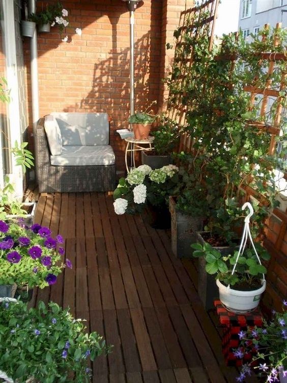 wooden trellises with planters with greenery and blooms are great to style a balcony and keep it more private at the same time