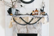 02 Halloween mantel with branches in a bucket with favors, banners, faux birds and a black framed mirror