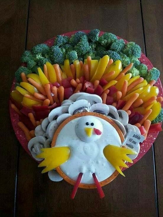 a cute turkey-shaped veggie tray with various veggies and dip styled as a bird