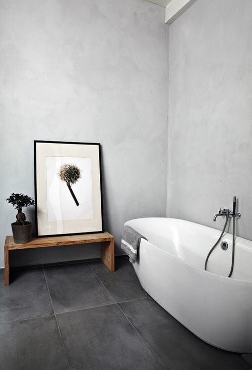 stucco walls and large tile floors for a minimalist bathroom