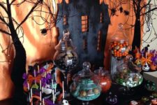 04 a haunted dessert table with a black house, bats, trees and lots of themed desserts