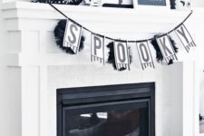 04 a modern black and white Halloween mantel with a banner, wreaths and lots of different stuff