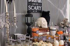 06 a simple stylish dessert table decor with black and white stripes, vintage candle holders and skulls
