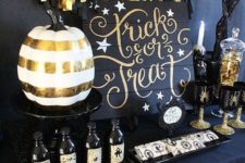 07 a stylish black and gold dessert table with a banner, a calligraphy sign and skulls